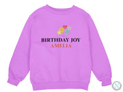 a purple sweatshirt with the words birthday joy on it