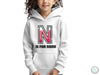 a young girl wearing a white hoodie with the letter n on it