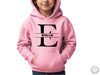 a young boy wearing a pink hoodie with the letter e on it