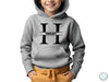 a young boy wearing a hoodie with the letter h on it